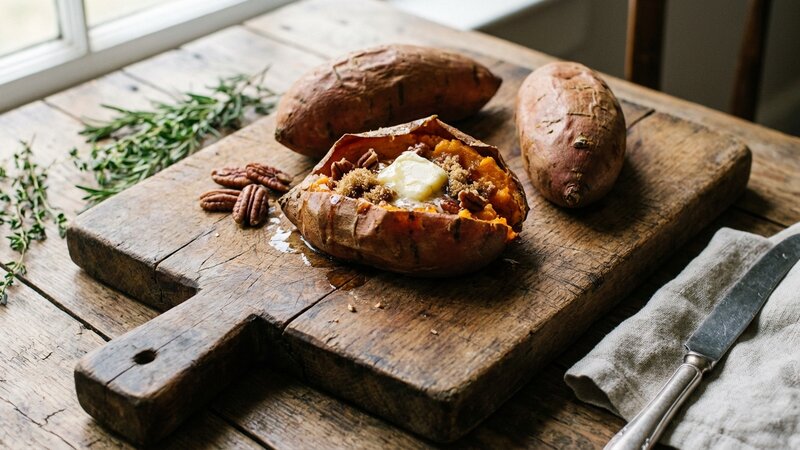 Baked sweet potatoes on a rustic wooden cutting board