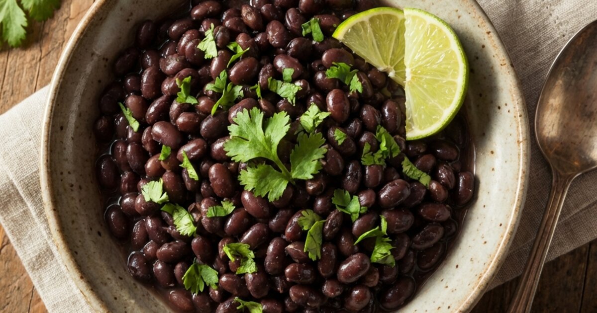 Bowl of cooked black beans garnished with cilantro - 15g protein, 41g carbs, 15g fiber per cup